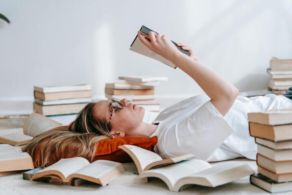 A woman reading and surrounded by books