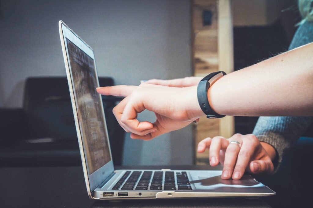 A person pointing at the laptop screen