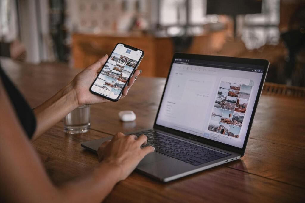 A person using a laptop and mobile phone