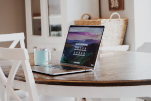 Laptop on a table displaying Google search page with a coffee cup beside it