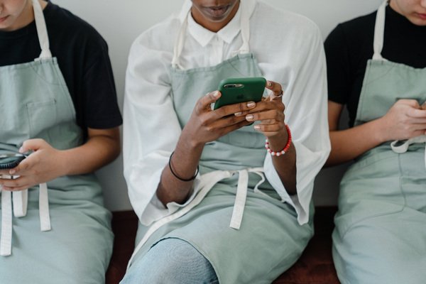 Coworkers browsing on their mobile phones during free time.