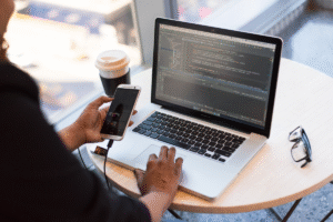 Person managing Google Ads using automation scripts on a laptop