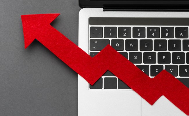 2.	Red upward arrow overlaid on a laptop keyboard, representing the improvement and effectiveness that audience segmentation delivers for Google Ads success.