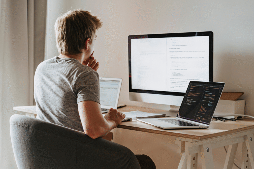 Man writing Google Ads scripts on dual computer monitors