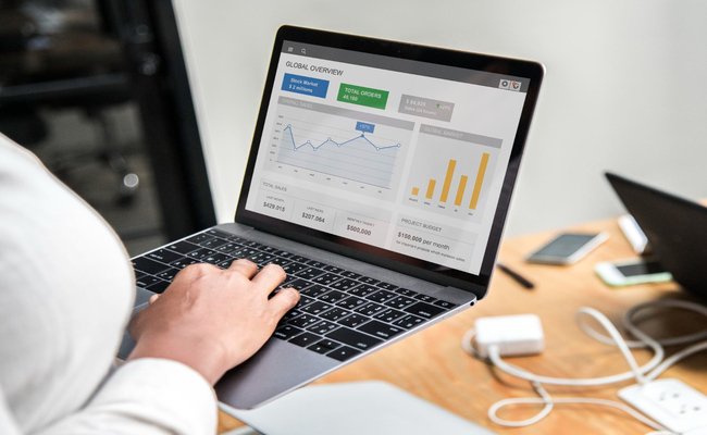 4.	A businesswoman focused on a laptop displaying detailed business reports and data visualizations, embodying the strategic and data-driven insights defining "The Future of Audience Segmentation" in advertising.