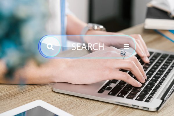 Hands typing on laptop with search bar showing long-term SEO traffic building.