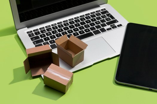 Laptop with cardboard boxes demonstrating shared features between Google SEO And Amazon SEO.