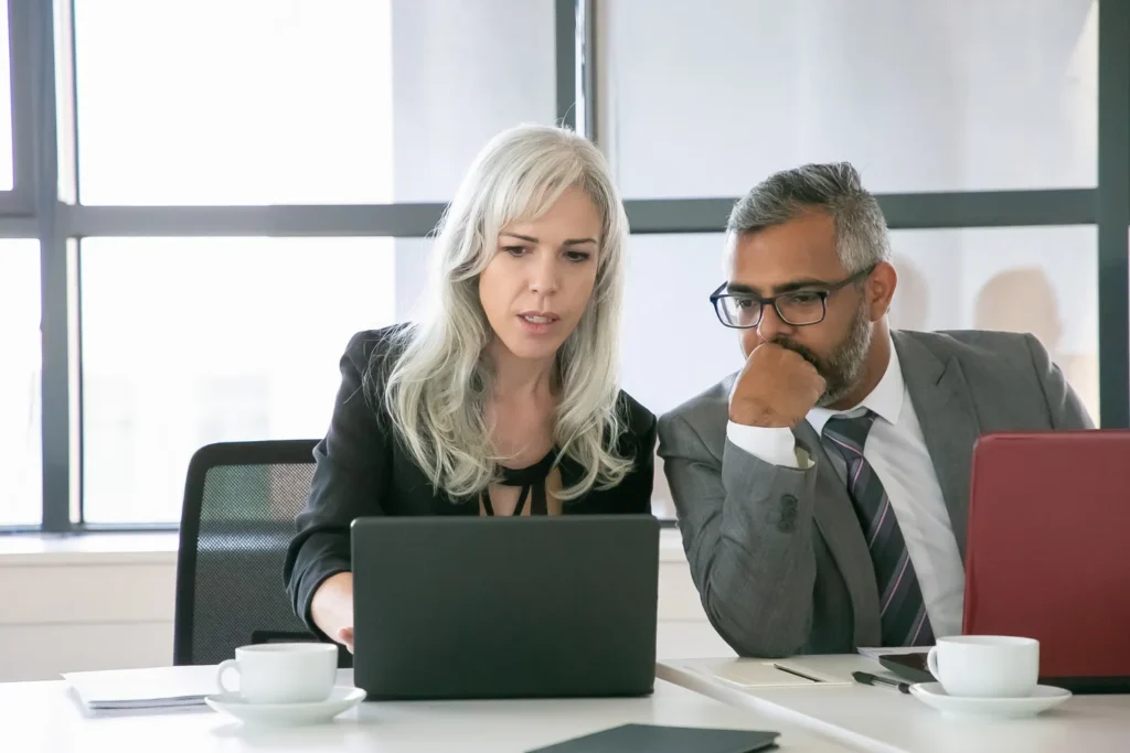 SEO specialist showing presentation on laptop to colleague