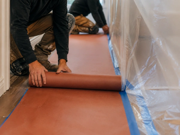 Remodeling crew laying floor protection before a renovation
