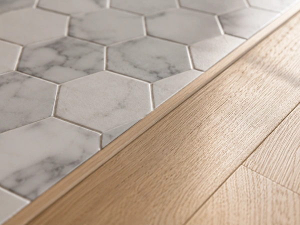 Close-up of a tile-to-hardwood floor transition in a bathroom remodel