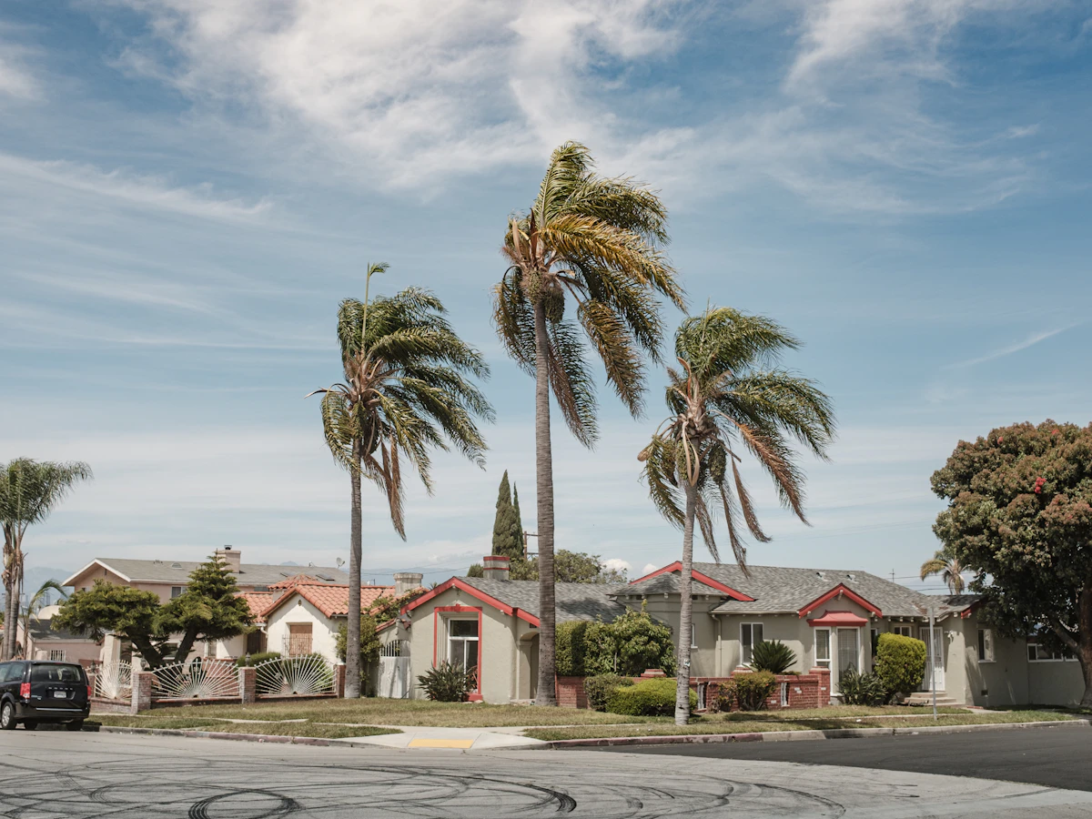 A white and red house beside palm trees in a residential part of Inglewood, California